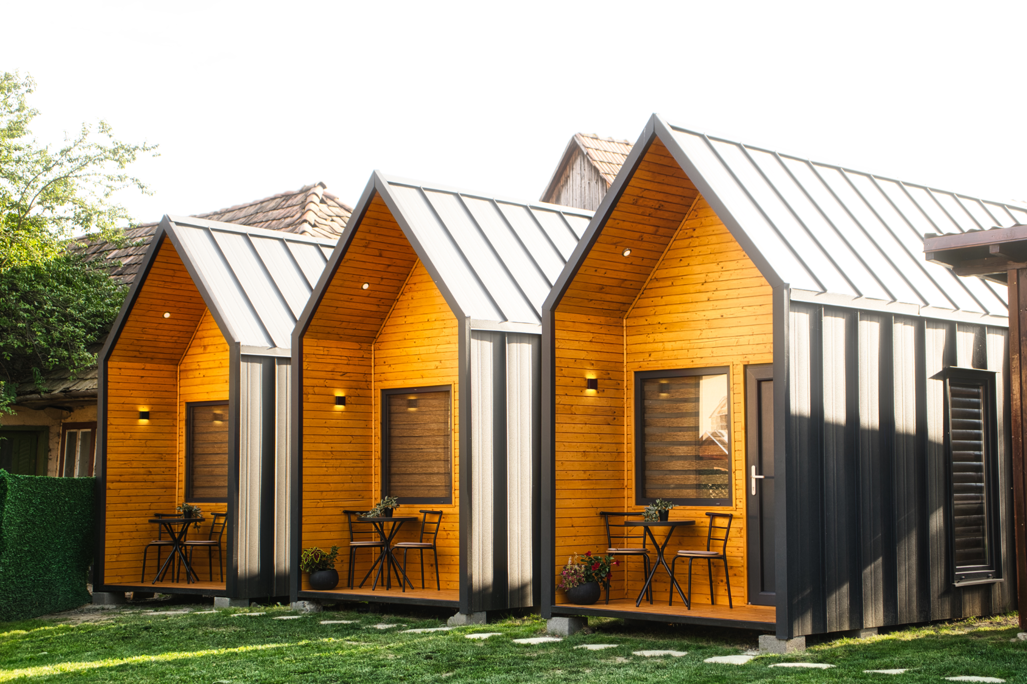 Három fa homlokzatú Via Mini Homes mobilház egymás mellett