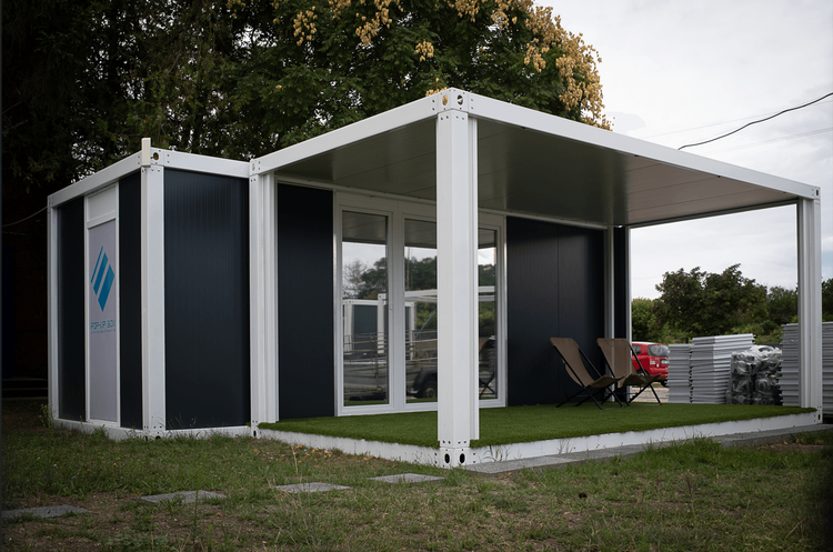 Modern konténerház terasszal, szendvicspanel moduláris épület kültéri bútorokkal és nagy üvegajtóval